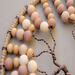 left view details of wire wraps attached to hoop, earthy color wooden beads, delicate twisted branches